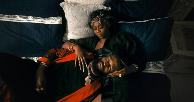 A woman lying on bed with a man laid on top of her